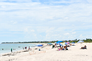 People enjoying a sunny beach day in Vero Beach, Florida on Hutchinson Island