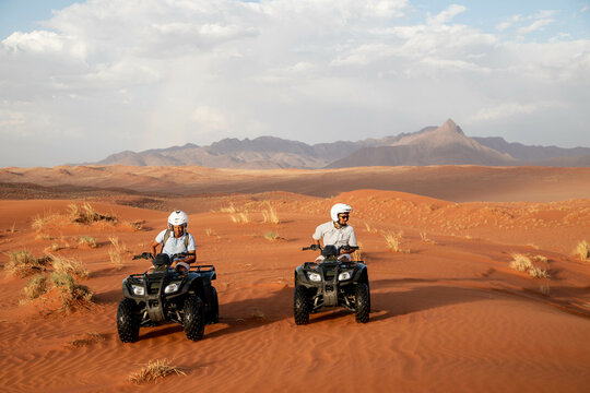 tourists driving 4x4 through the red desert of namibia
