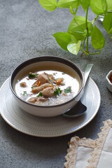 a bowl of chicken soup in grey background