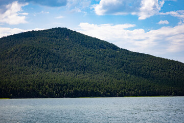 Lake and in the background is a mountain. Beach for relaxation in a mountainous area.