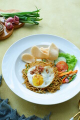 a plate of fried noodles served with vegetables 
