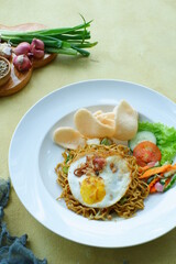 a plate of fried noodles served with vegetables 