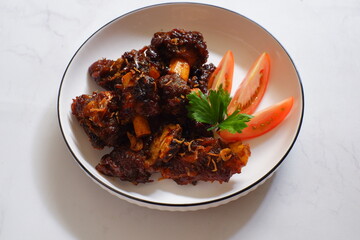 a plate of grilled beef ribs served with vegetables 