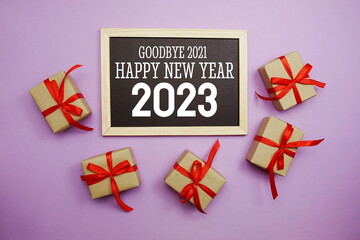 Happy New Year 2023 typography text with gift box on purple background