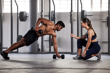 Muscular, sports man with female gym instructor or fitness coach doing body building workout, push up plank exercise. Active male athlete weightlifting in wellness center with trainer for motivation.