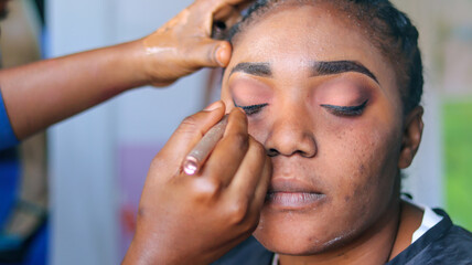 Obraz na płótnie Canvas Using eyeliner pencil on the eyes of a lady having makeup at the makeup studio.