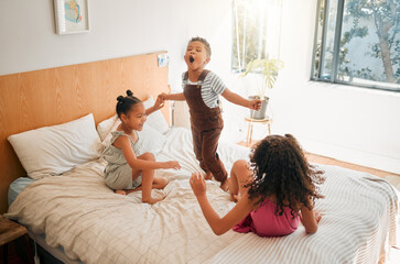 Children, fun and energy by playing siblings jumping, bonding and enjoying a game on bed at home...