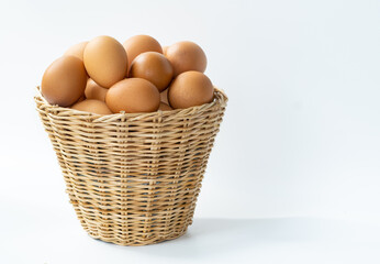 Eggs from a good breed of hens put together in a woven basket on a white background.  Eggs are...
