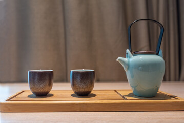 Pouring tea from a teapot into a cup on the table