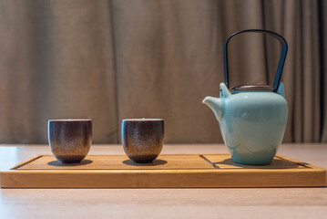Pouring tea from a teapot into a cup on the table