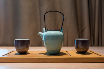 Pouring tea from a teapot into a cup on the table