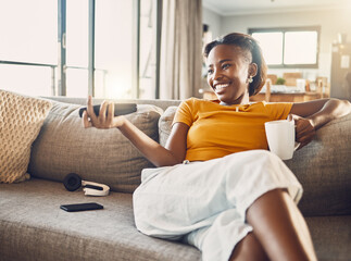 Relaxed, carefree and smiling young female watching tv and streaming movie at home on her living...