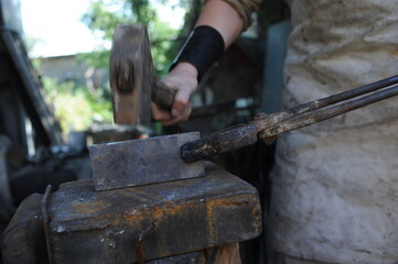 Almaty, Kazakhstan - 09.24.2015 : A blacksmith makes a metal holder for knives and tools in the workshop.