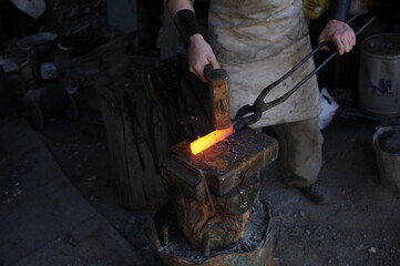 Almaty, Kazakhstan - 09.24.2015 : A blacksmith makes a metal holder for knives and tools in the...