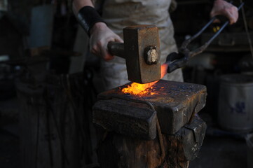 Almaty, Kazakhstan - 09.24.2015 : A blacksmith makes a metal holder for knives and tools in the workshop.