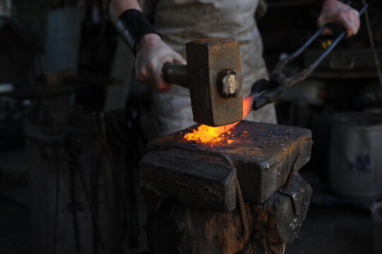 Almaty, Kazakhstan - 09.24.2015 : A blacksmith makes a metal holder for knives and tools in the workshop.