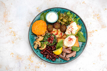 oriental breakfast with egg greens sausages in a blue plate on a white background
