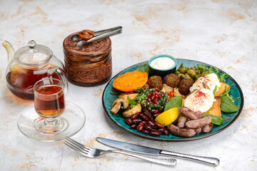 Fototapeta na wymiar oriental breakfast with egg greens sausages in blue on a white background with tea 