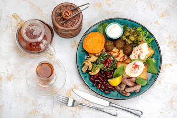 oriental breakfast with egg greens sausages in blue on a background with tea
