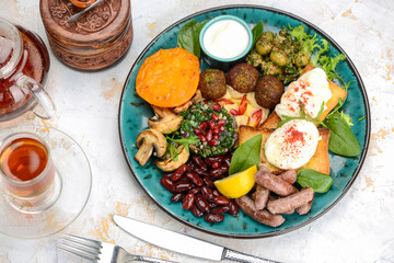 oriental breakfast with egg greens sausages in blue on background with tea top view

