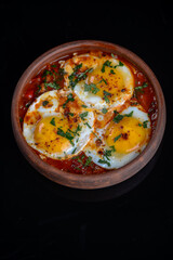fried scrambled eggs in a clay pan vertical photo

