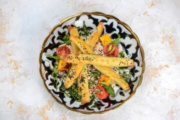 fried quinoli in a plate with tomatoes and greens
