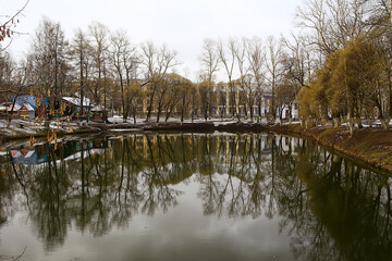 Fototapeta premium early spring in the park, abstract seasonal view trees april snow