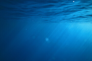 ocean underwater rays of light background, under blue water sunlight