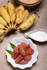 boiled bananas in syrup topped with coconut milk