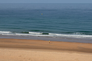 people walking along the seashore, early in the morning, at La Barrosa beach in Sancti Petri, Cadiz, Spain