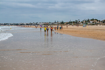Obraz premium people walking along the seashore, early in the morning, at La Barrosa beach in Sancti Petri, Cadiz, Spain