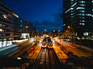 tram, train  stop at night. with urban city lights, car light trails