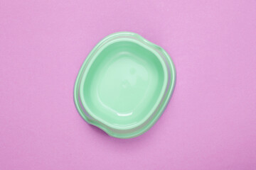 Empty bowl for cat food on purple background. Top view