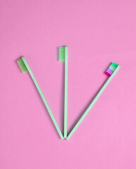 Eco-friendly bamboo toothbrushes on pink background. Top view.