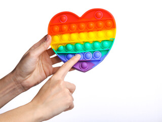 Hand holding Popular antistress pop it toy in the shape of heart isolated on white background