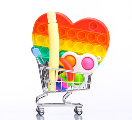 Mini shopping cart with antistress toys isolated on white background