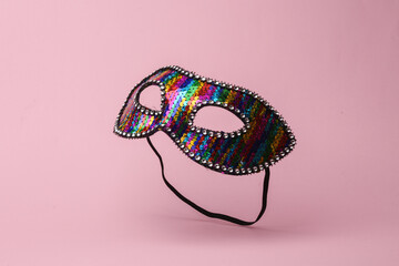 Carnival masquerade mask flying in antigravity on pink background with shadow. Levitation object in...