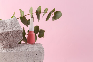 Nail polish bottle on stone with eucalyptus branch. Natural cosmetics, beauty concept. Modern still...