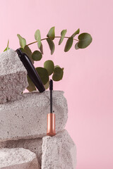 Tube mascara with brush on stone with eucalyptus branch. Natural cosmetics, beauty concept. Modern...