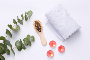 Spa, relax, aromatherapy concept. Aroma candles with comb, towel and eucalyptus sprig on white...
