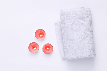 Spa, relax, aromatherapy concept. Aroma candles with towel on white background. Flat lay
