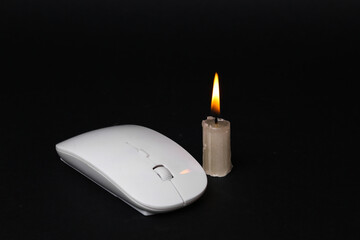 Pc mouse with flaming candle on black background