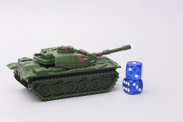 Military tank with dice on a gray background