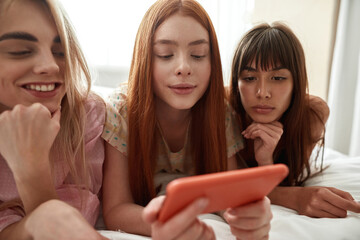 Girlfriends watching mobile phone in hand of girl