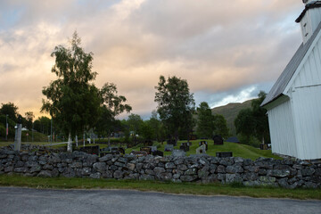 Sad little child, blond boy, standing in rain on cemetery, sad person, mourning