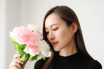 ピンクの花（ラナンキュラス）と美しい日本人女性