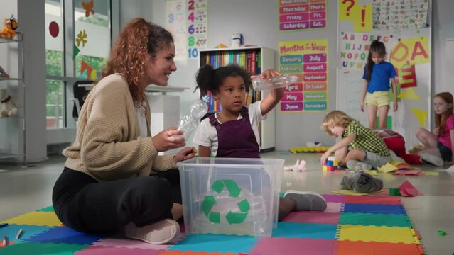 Female teacher teaches students about recycling.