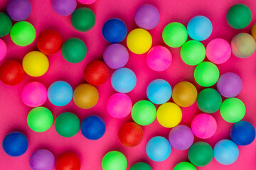 Abstract colored balls background. Multi-colored taw toy scattered on bright paper. Base for design nice backdrop, wallpaper, poster. Noisy surface texture