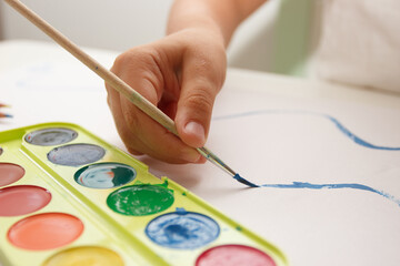 Child drawing a picture by watercolor, back to school concept