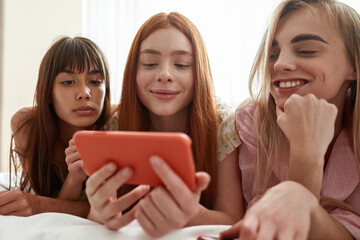 Girlfriends watching smartphone in hand of girl